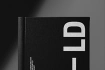 Black book spine detail, cream lock emboss, modern minimalist