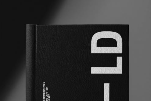 Black book spine detail, cream lock emboss, modern minimalist