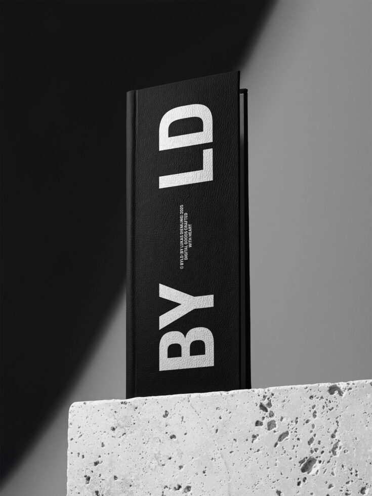 Charcoal hardcover book on concrete base with white vertical letters BYL displayed