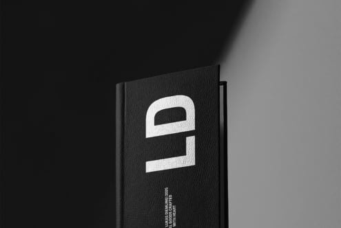 Black hardcover book angled showing white geometric logo design