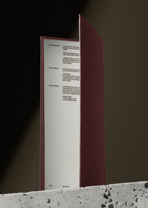Burgundy hardcover book standing open against warm background with usage guide