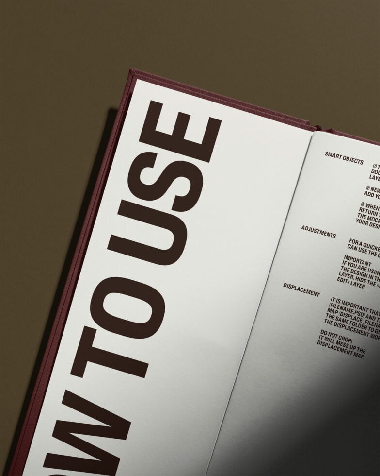 Open hardcover book with burgundy spine on olive background showing interior pages