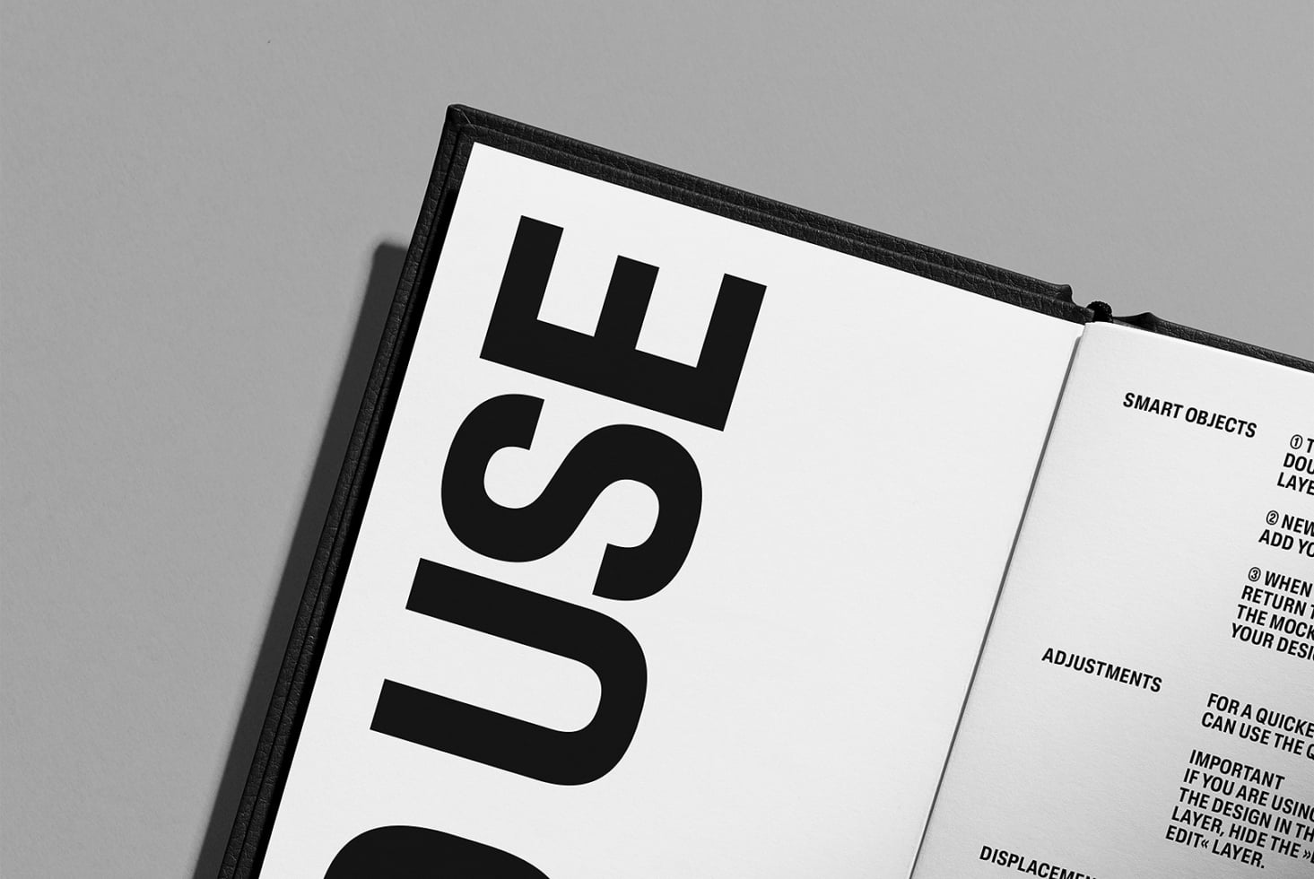 Open hardcover book with black spine on gray background showing numbered pages
