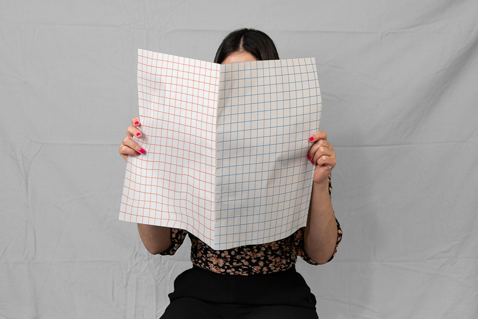 Woman holding open notebook with grid lines, two-sided mockup layout