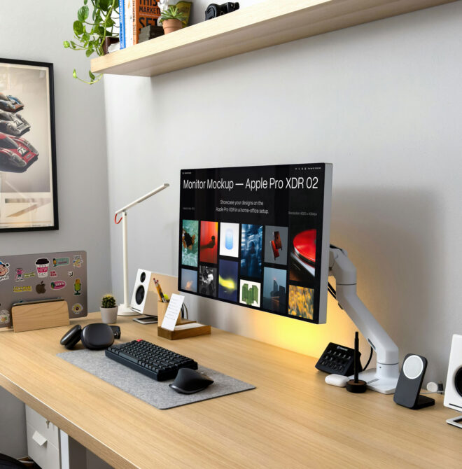 Apple Pro XDR monitor on wooden desk with warm lighting, keyboard, mouse