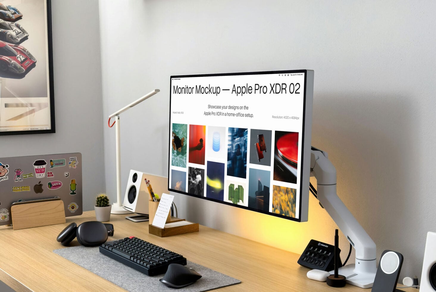 Desk setup with monitor mockup displaying portfolio, sticker-covered laptop visible