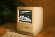 Vintage Macintosh Classic computer displaying retro game Glider on screen