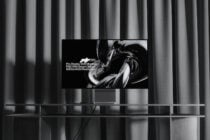 Modern living room with TV on striped curtain backdrop showing abstract swirl design