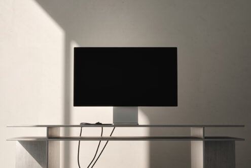 Desktop monitor on minimalist metal stand with cable management