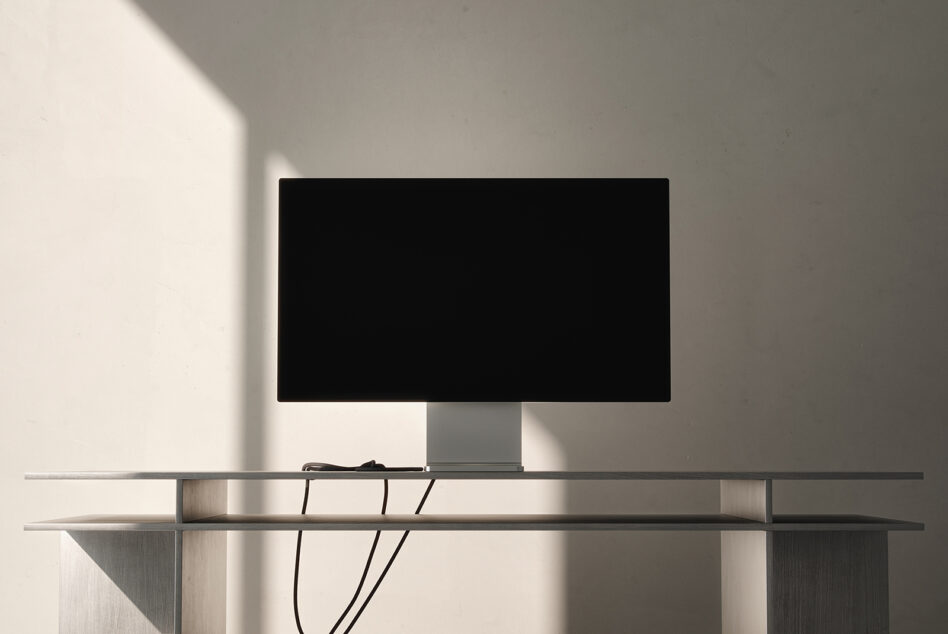Desktop monitor on minimalist metal stand with cable management