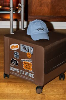 Brown hand cart with stickers, light blue cap on display stand