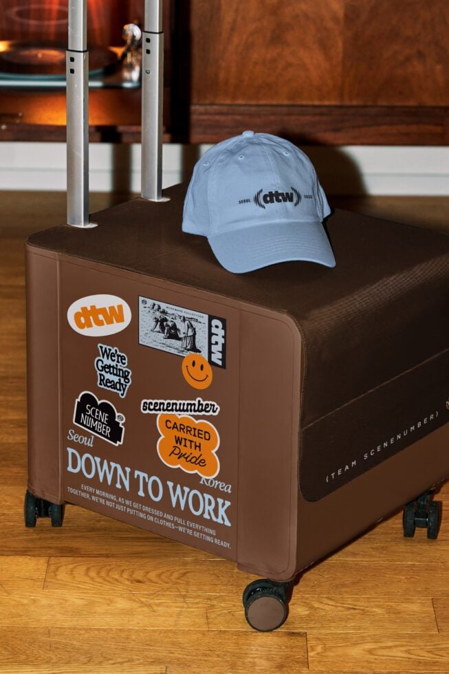Brown hand cart with stickers, light blue cap on display stand