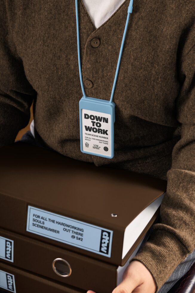 Blue lanyard with white badge on brown cardigan, file folder mockup styling