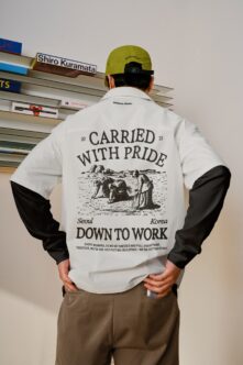 White with black sleeves jacket displaying 'Carried with pride' back graphic engraving paired with lime green cap, Down to Work collection