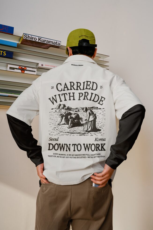 White with black sleeves jacket displaying 'Carried with pride' back graphic engraving paired with lime green cap, Down to Work collection