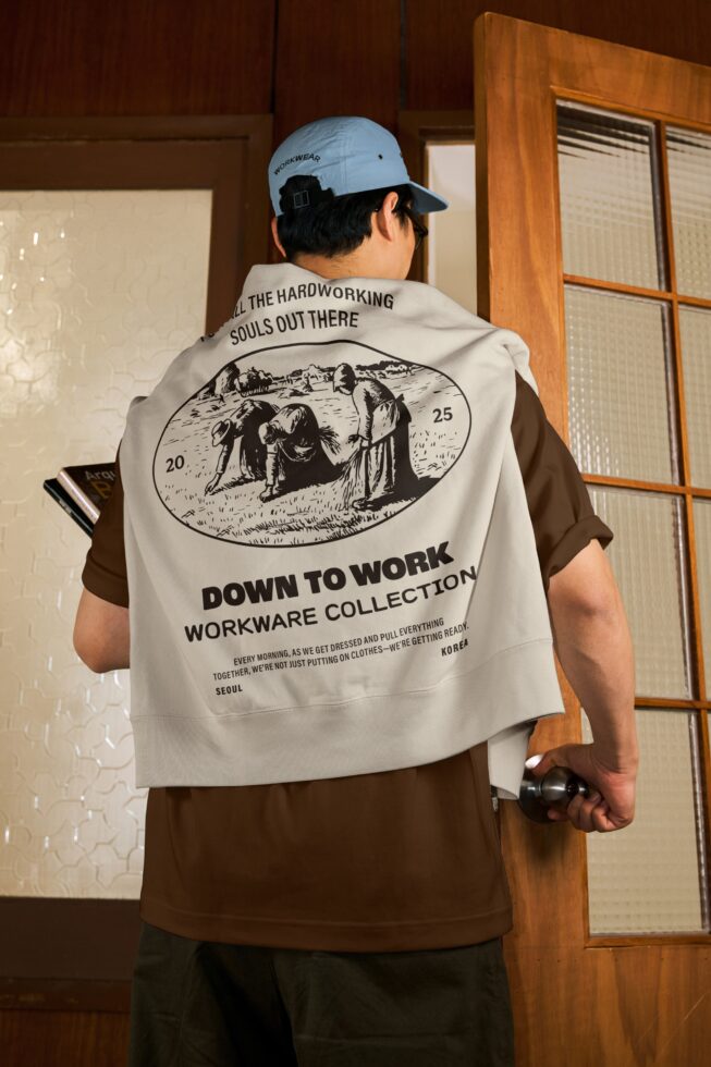 Person wearing light blue cap cream vest showing Down to Work workwear collection back print