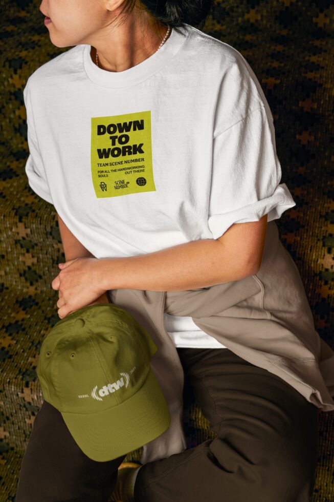 White tee with yellow front patch, green Scene Number cap