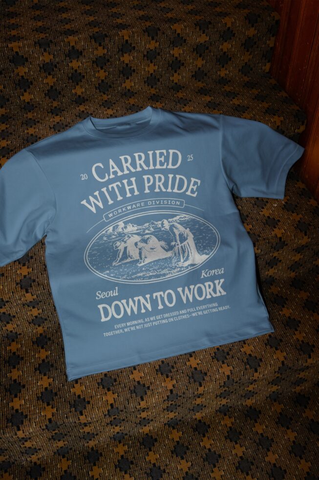 Blue tee with Carried With Pride graphic, engraved workers illustration centered