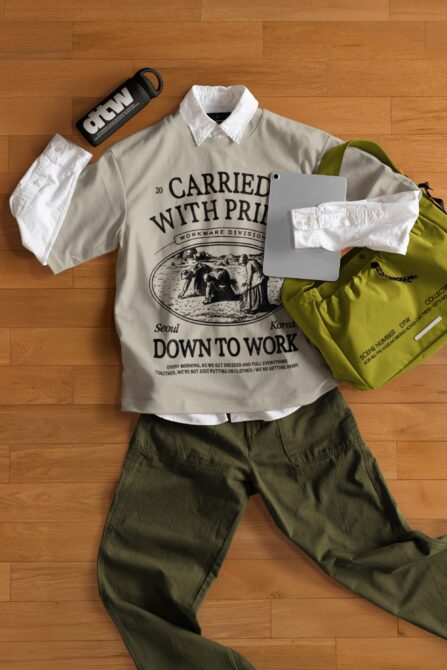 Flat lay of beige graphic tee, white shorts, lime backpack, speaker on wood floor
