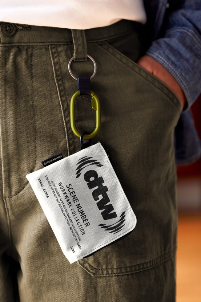 White fabric tag with yellow carabiner attached to cargo pants pocket