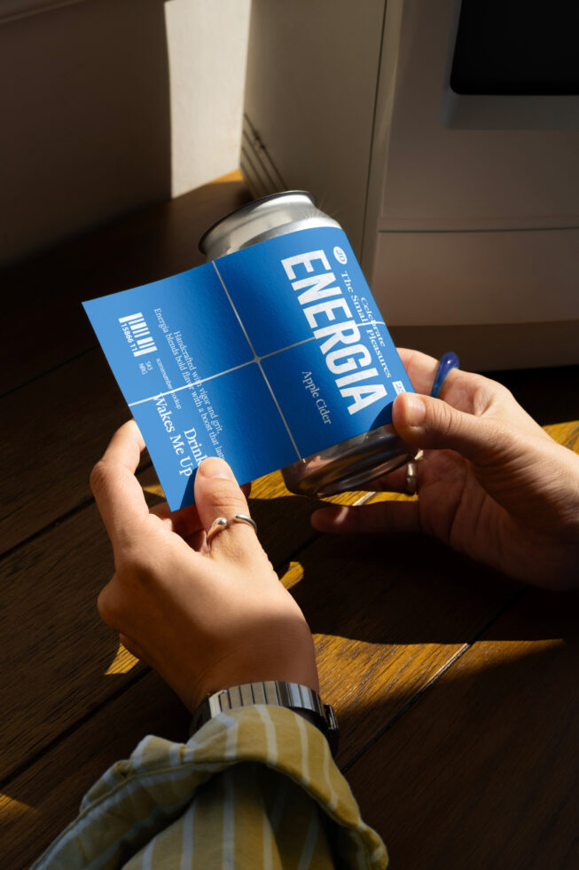 Hands holding blue can label mockup, displaying customizable design on aluminum beverage can