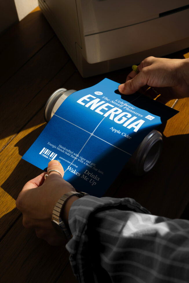 Hands holding blue can label mockup showing customizable label design, ring color, shirt color