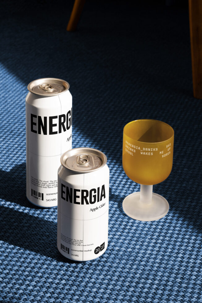 Two white Energia cans with yellow wine glass on blue carpet