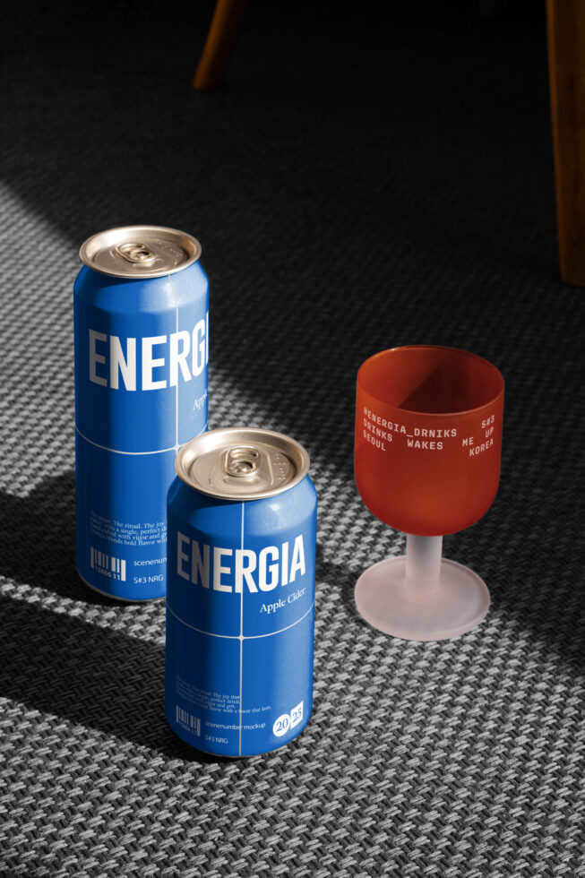 Energia cans with orange wine glass on textured blue carpet