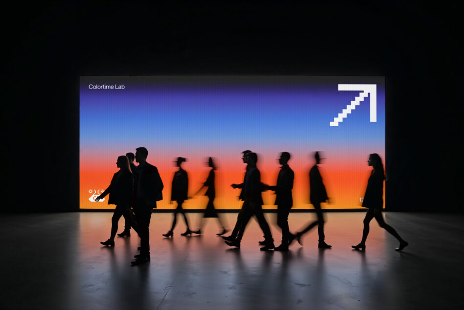 People silhouettes walking past large screen showing sunset gradient with growth arrow icon
