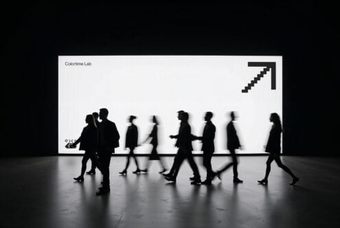 Moving crowd silhouettes in front of bright white display screen with upward arrow symbol