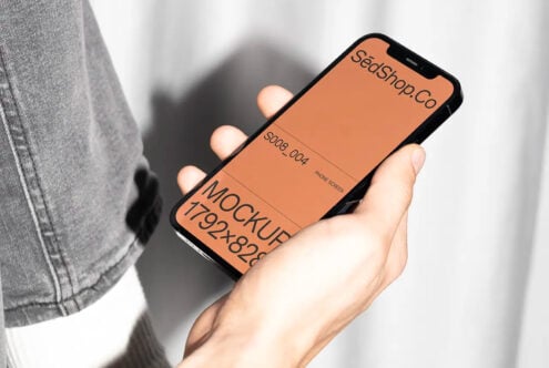 Hand holding iPhone mockup with peach screen displaying SedShop.Co branding