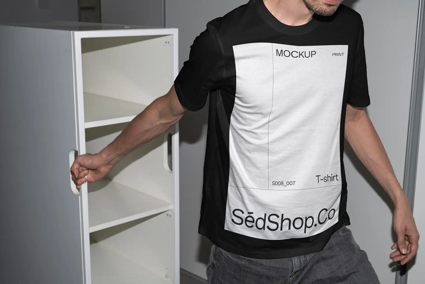 Man wearing black tee with white print mockup holding cabinet, showing text label design
