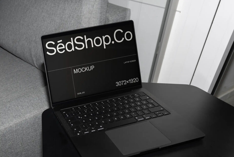 Black laptop on couch displaying SédShop branding with dark screen mockup