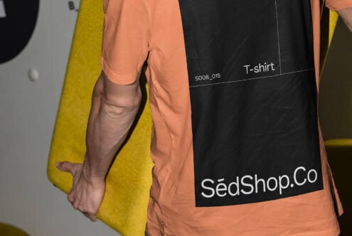Peachy orange shirt with yellow cardigan draped over arm showing fabric texture