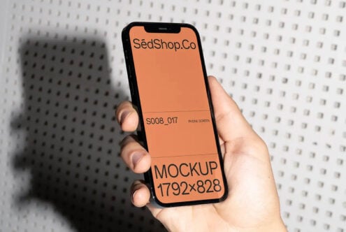 Orange iPhone screen mockup held in hand with peach background display