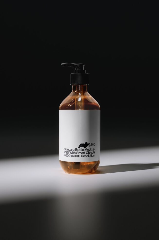 Amber glass pump bottle with white label showing skincare product mockup on dark background