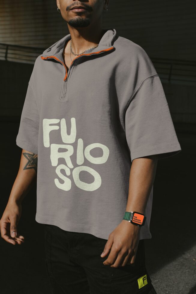 Gray polo shirt mockup with cream text logo on chest with smart watch