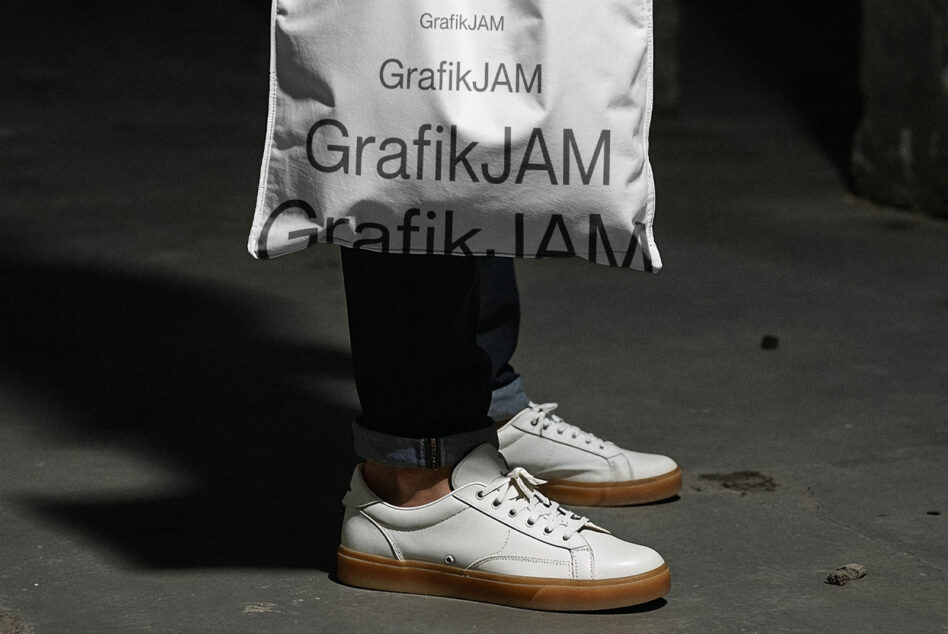 White sneaker with gum sole on concrete, person wearing white shirt overhead