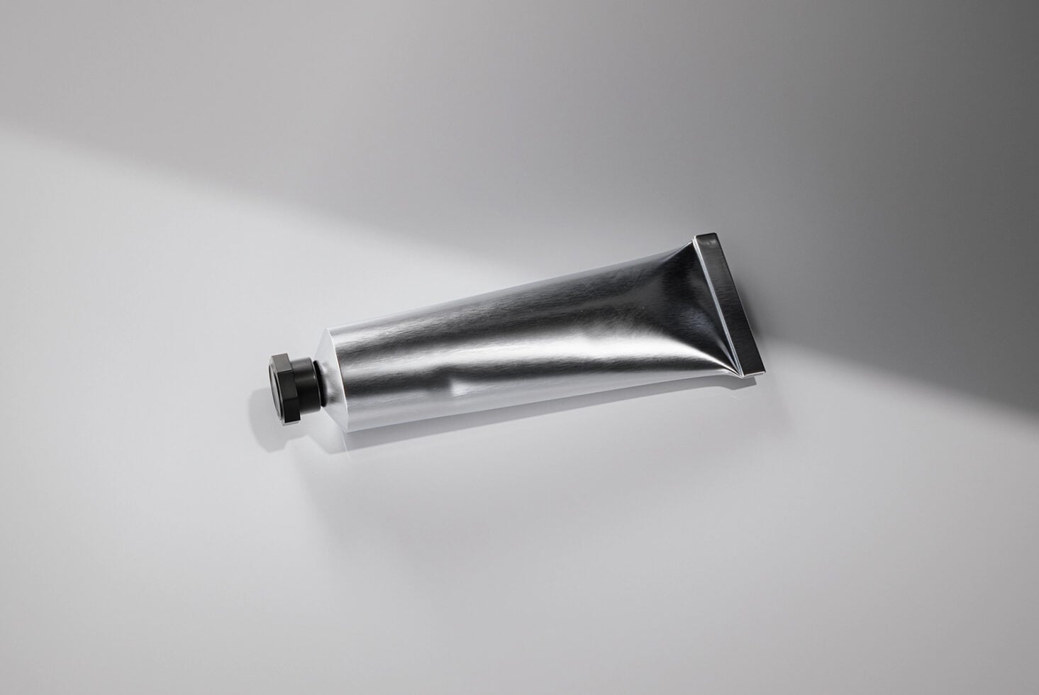 Empty metallic squeeze tube with black flip-top cap mockup