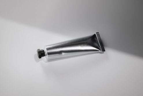 Empty metallic squeeze tube with black flip-top cap mockup