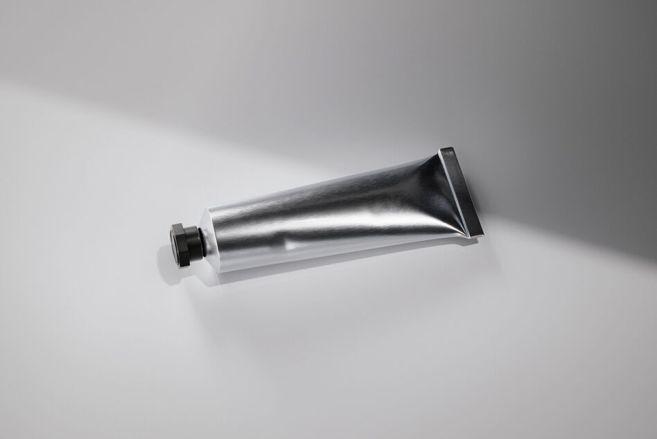 Empty metallic squeeze tube with black flip-top cap mockup