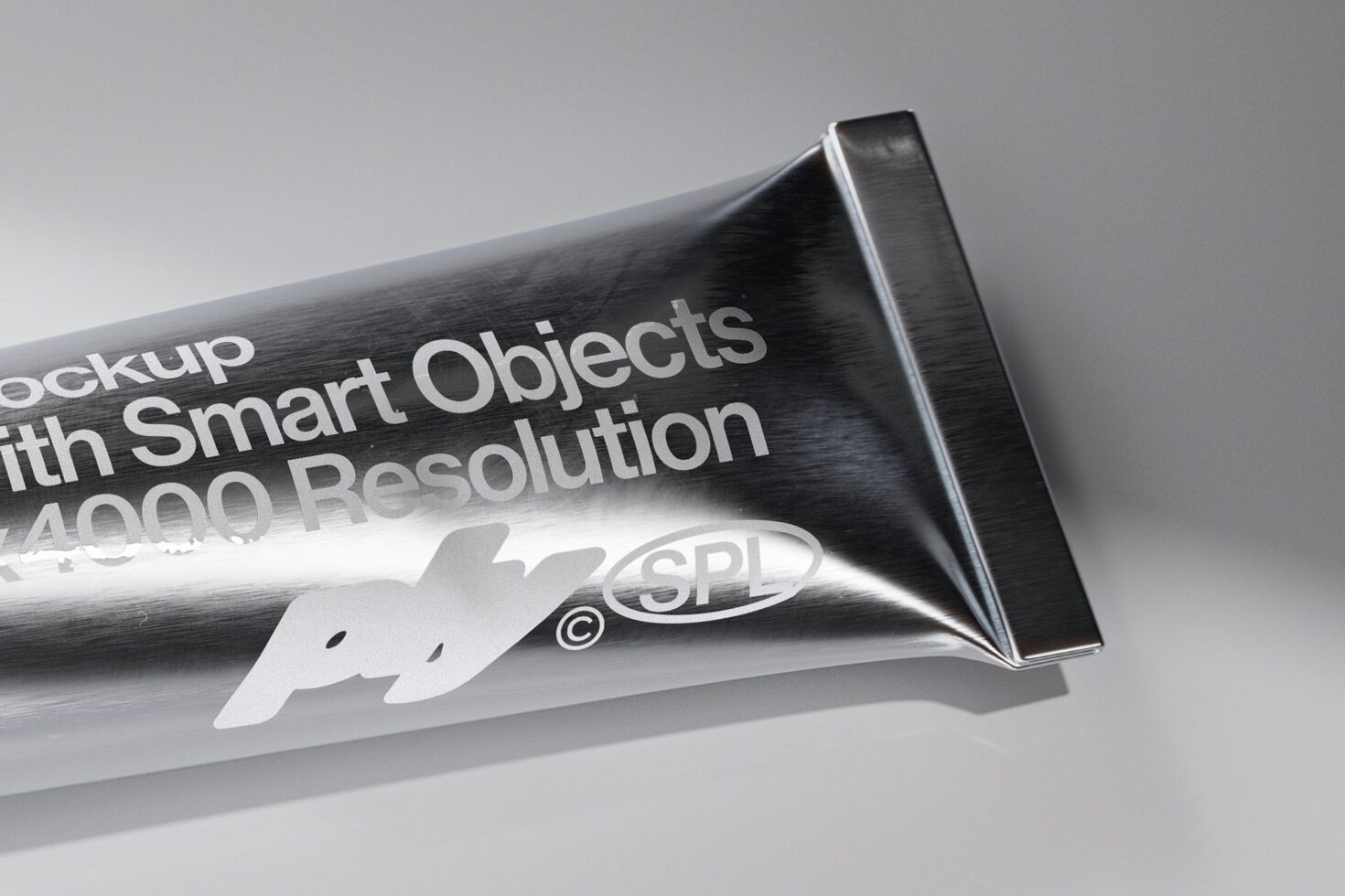 Close up of metallic tube squeezed flat with embossed text detail