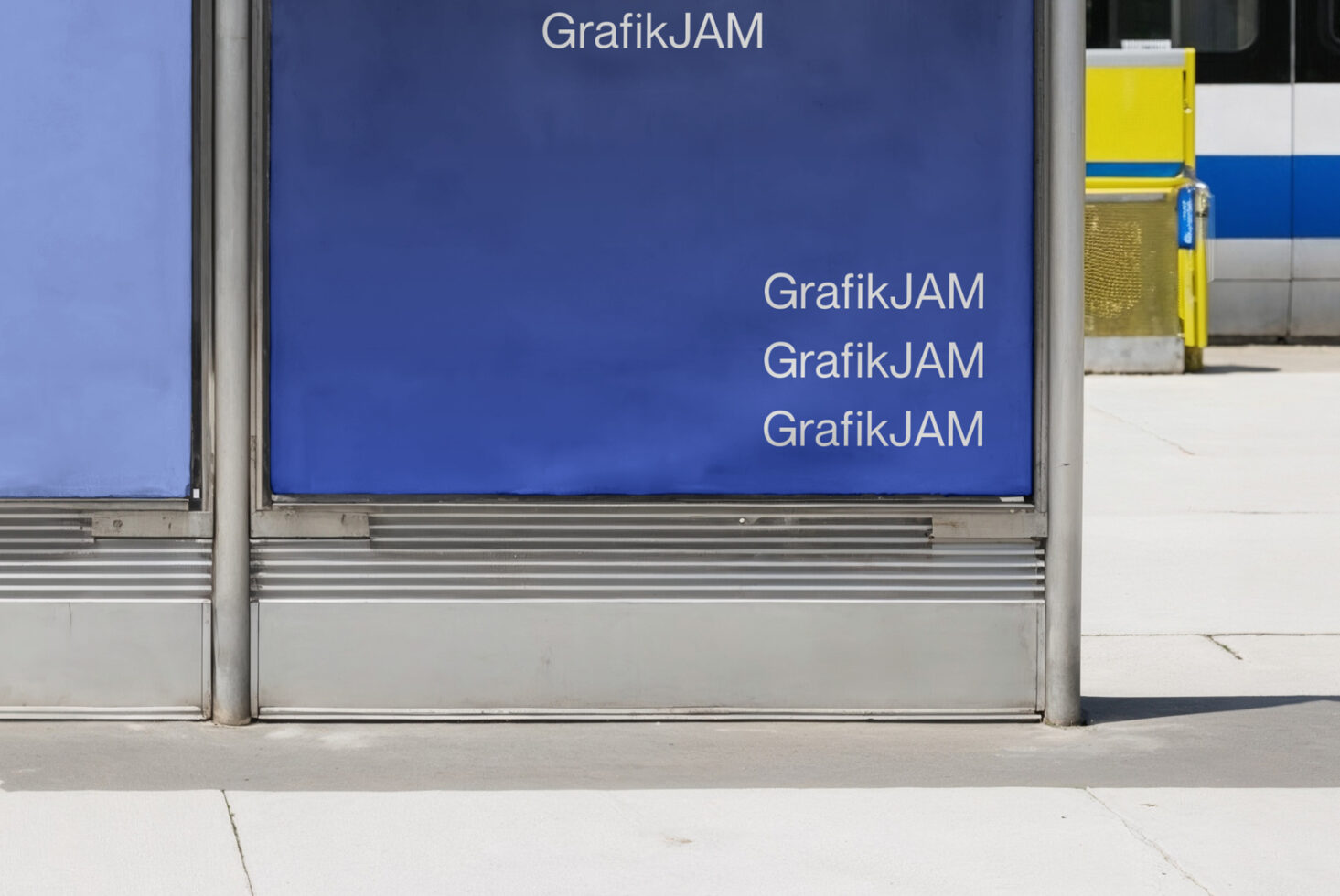 Blue bus shelter billboard with GrafikJAM text repeated, yellow container visible