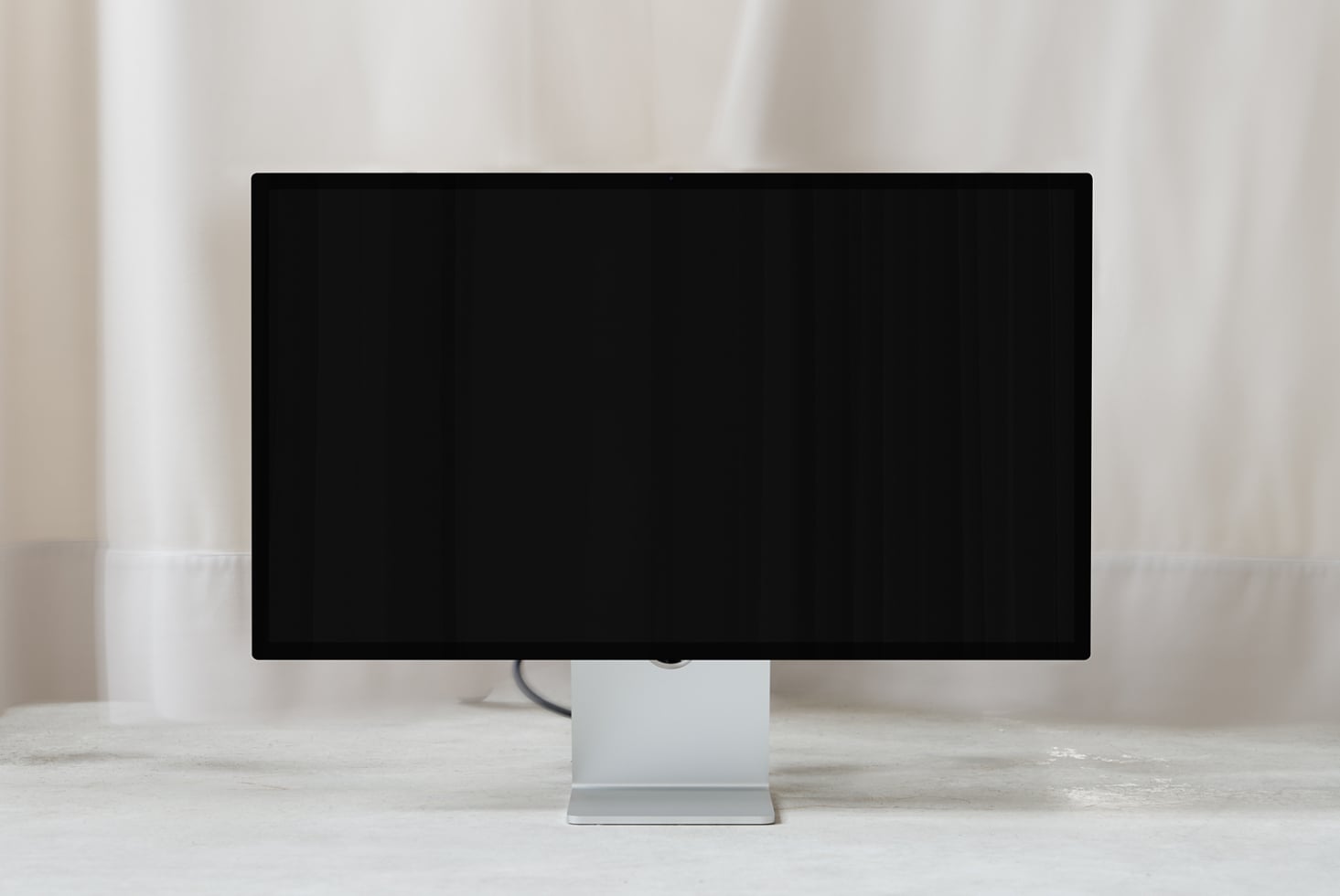 Desktop monitor mockup with blank black screen on white stand