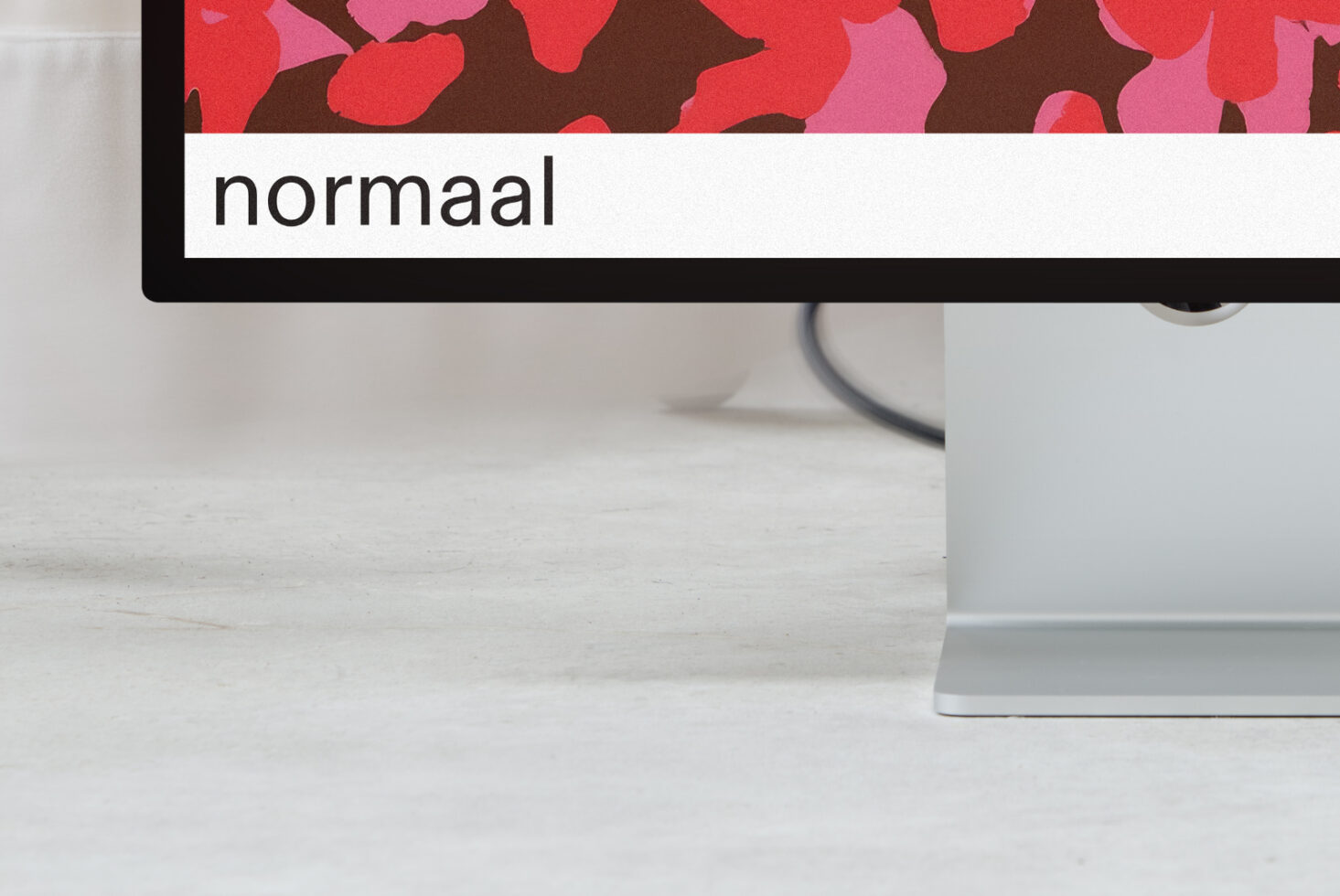 Monitor mockup showing red pink floral pattern with normaal text label
