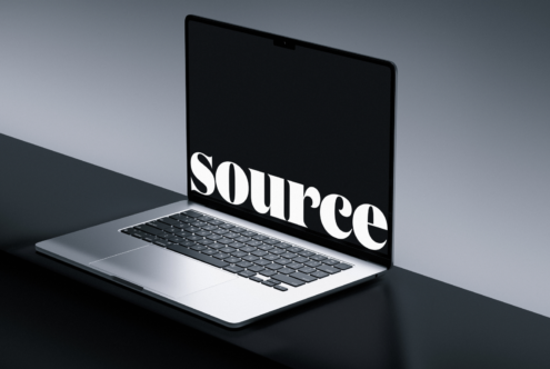 Angled laptop view displaying bold white serif font on dark display