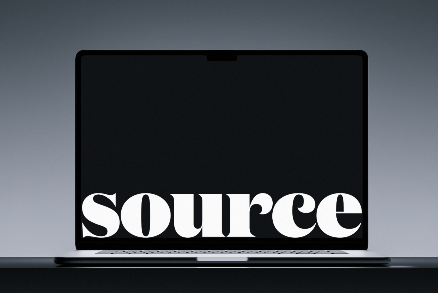 Laptop closed showing white serif text on black screen against gray surface