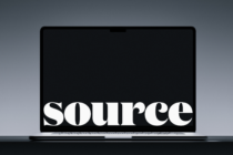 Laptop closed showing white serif text on black screen against gray surface