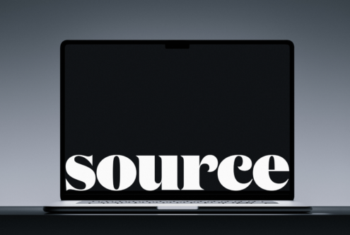 Laptop closed showing white serif text on black screen against gray surface