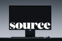 Desktop monitor with keyboard showing white serif typography on black screen